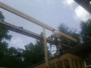 Carpenter setting a ridge beam over a new addition frame — Ice Dam Removal by Roofing Brothers in Ephraim