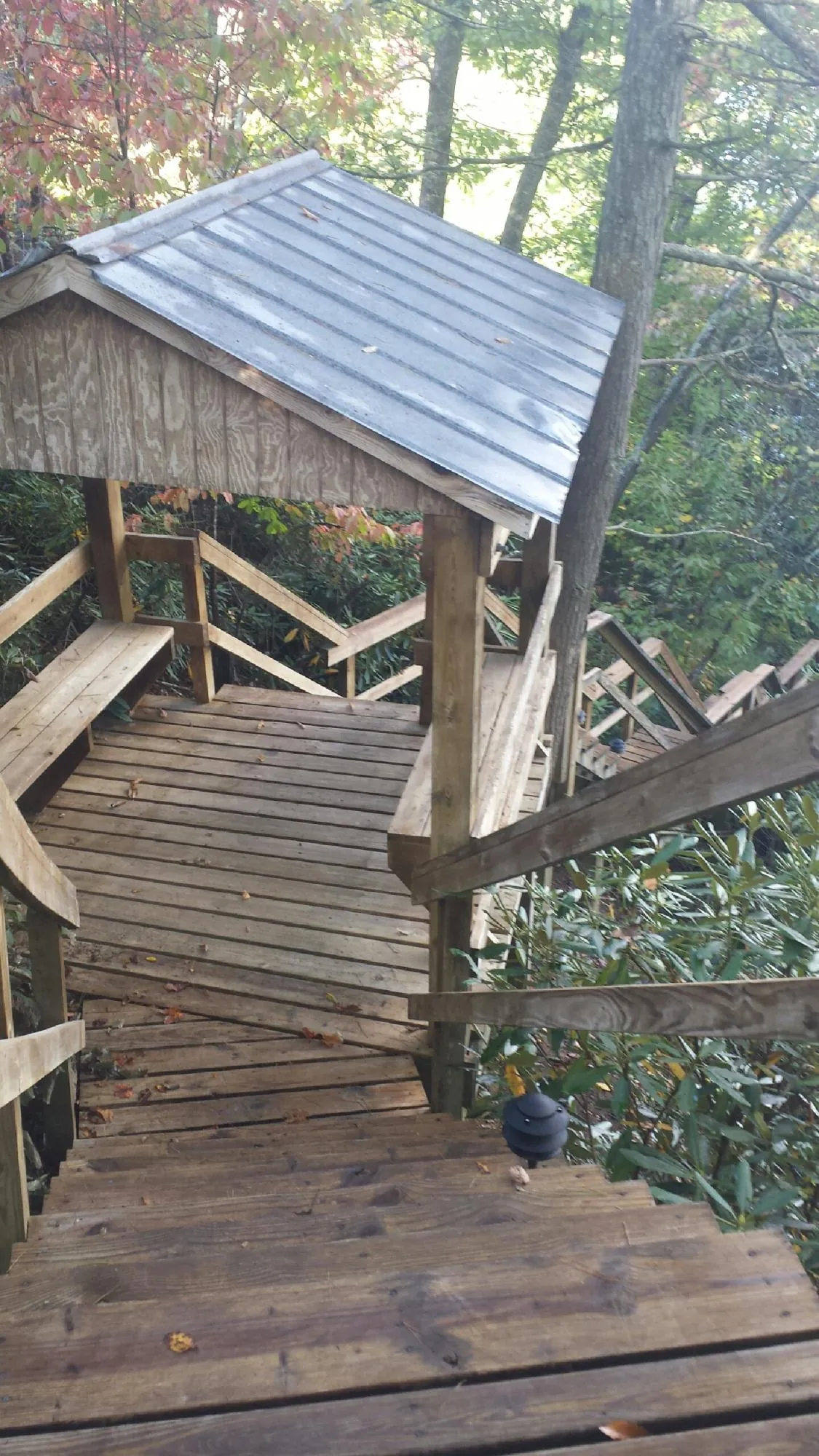 Metal roofed shelter over wooden steps on a wooded walkway — Skylight Repair & Installation work by our crew in Ephraim